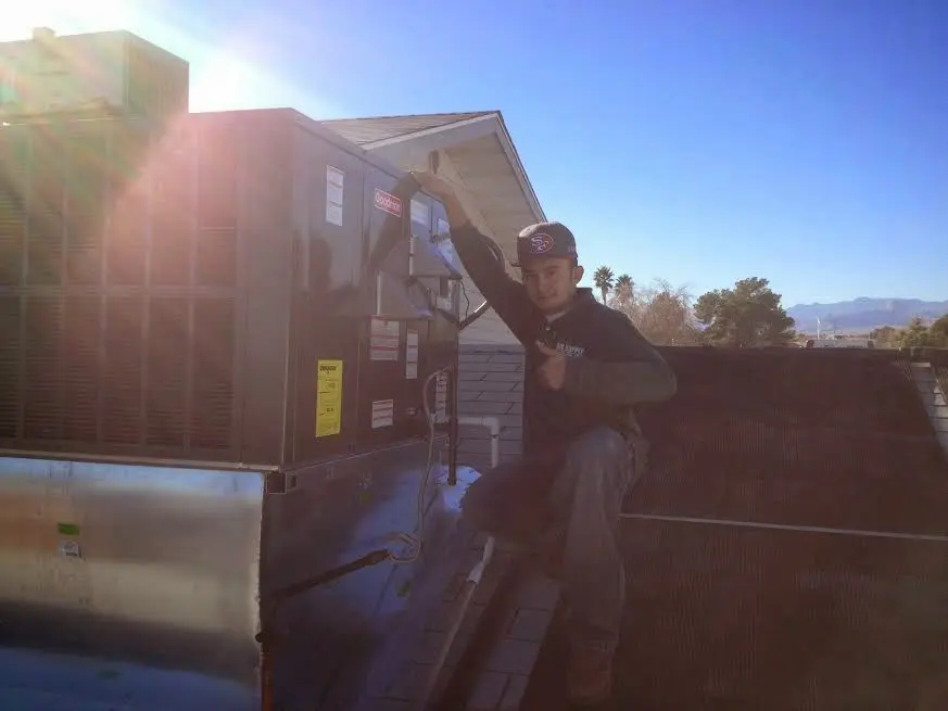 HVAC technician performing Air Duct Repair on a rooftop unit in Mequon